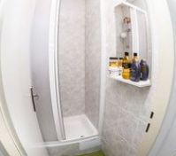 Compact shower cabin with shelf