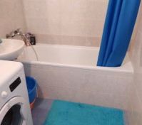 Bathroom with bathtub and washing machine