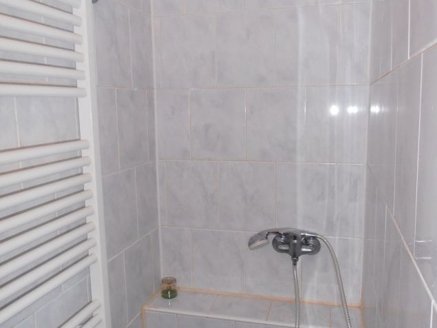  V koupelně se nachází sprchový kout s topným žebříkem, umyvadlo, koupelnová skříňka a pračka.