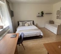 Spacious bedroom with desk and sofa