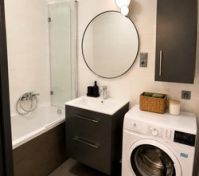 Bathroom with bathtub and washer