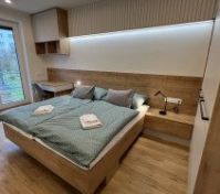 Ložnice s manželskou postelí a pracovním stolem a výhledem do zahrady