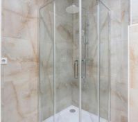 Glass shower enclosure marble tiles