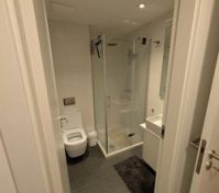 Bathrrom with corner shower and heated floor and towel rack