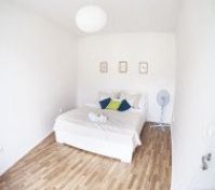 Cozy white bedroom with double bed