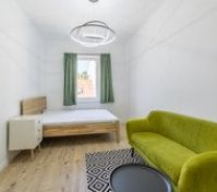Bright bedroom with green sofa