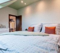 Bedroom with double bed orange pillows