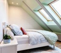 Cozy bedroom with skylight sloped ceiling