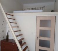 The double bed is on the mezzanine. There is a space downstairs where it is possible to add a single bed or a desk. Right now there is an armchair a dresser and a litte table