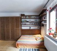 pokoj - pohled na šatní skříně a postel s knihovnou