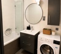 Bathroom with bathtub and washer