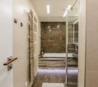 Bathroom entrance. Bathroom includes of large bath, shower, toilet, washbasin and huge LED mirror. Towels and soup is included.