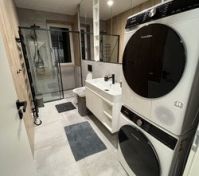 Koupelna se sprchovým koutem, pračkou a sušičkou