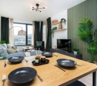 A beautifully designed space combining a cozy living area and elegant dining setup. Natural tones, green accents, and soft lighting create a warm and inviting atmosphere. Perfect for relaxing, enjoying meals, and making the most of your stay.